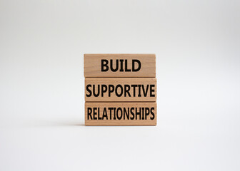 Build Supportive Ralationships symbol. Wooden blocks with words Build Supportive Ralationships. Beautiful white background. Business and Build Supportive Ralationships. Copy space.