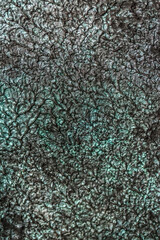 Green background from decorative plaster with abstract spots. Unusual green wall texture with beautiful patterns, creative surface background. Front covering for facing of buildings.