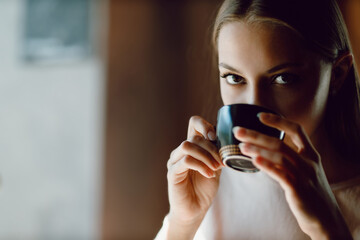 Young beautiful smiling woman enjoying drinking cappuccino coffee cup indoor cafe. Tea or coffee drink