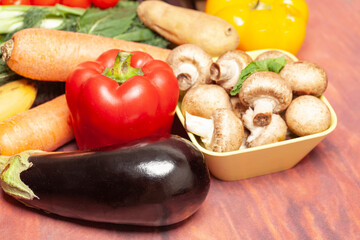 Vegetables and mushrooms on wooden table.