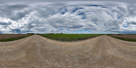 full seamless spherical hdri 360 panorama view on no traffic gravel road among fields with clouds in overcast sky in equirectangular projection, ready for VR AR
