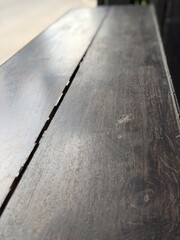 Picture of a wooden table on a wood grain floor, far away corner.