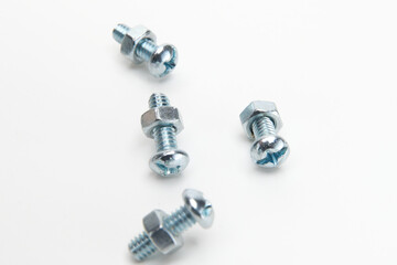 Philips head bolts attached to hexagonal nuts isolated on white 