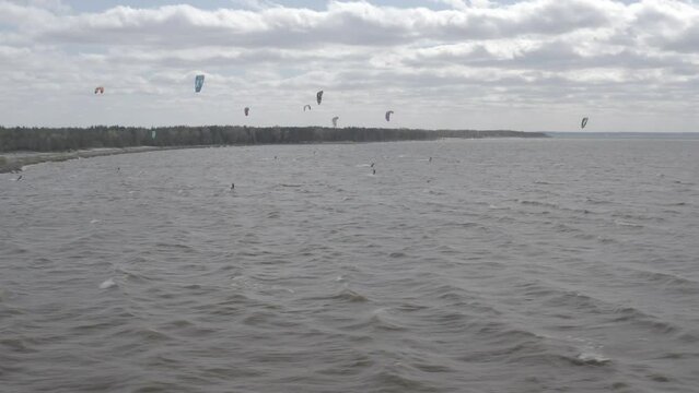 Ukraine. Kyiv. Athletes ride kite surfin. Kiev sea. Summer. Windy weather. Competition. Colored sails. Aerial.