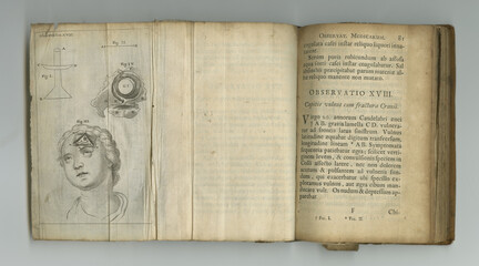 Aged medical knowledge. An old medical book with its pages on display. - obrazy, fototapety, plakaty