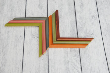 Modern colorful wooden frame corners on a wooden gray background. Neatly folded color sample...