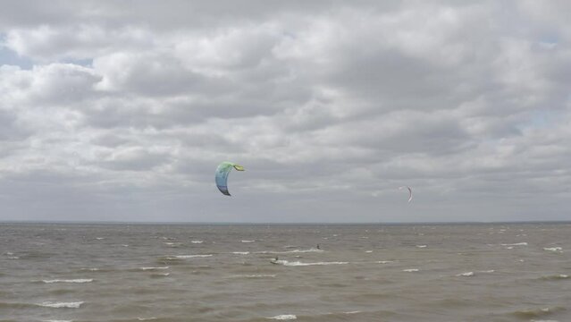 Ukraine. Kyiv. Athletes ride kite surfin. Kiev sea. Summer. Windy weather. Competition. Colored sails. Aerial.