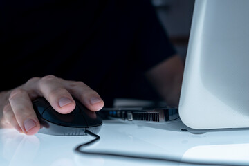 MALE HAND ON THE MOUSE USING LAPTOP. CONCEPT OF CYBER BULLYING, PEDOPHILIA, PEDERASTY, GROOMING, HACKING ATTACK, VIRUS, MALWARE, SHOPPING ADDICTION AND OTHER RISKS ON THE INTERNET.
