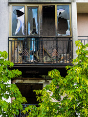 Blossoming rose bush on the background of ruined balconies of a house in Bucha, Kyiv region, after the Russian occupation (concept: unbreakable, unconquered, life will win death)