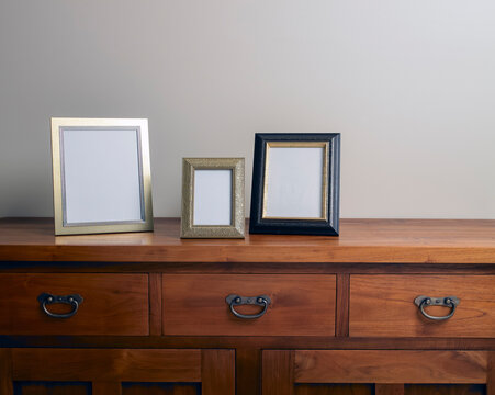 Assortment of blank photo frames on wooden cabinet