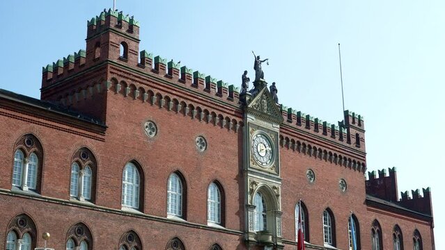 Detail of the clock and Italo-Gothic architecture of the Odense City Hall. The red brick building dates from the late 1800s. Odense, Fyn, Denmark