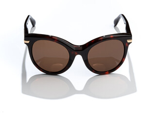 Women sunglasses in sunlight on white background. Modern stylish sunglass for holiday vacation....