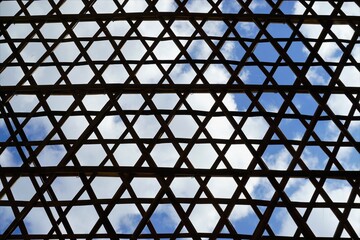 Innenansicht von Dach aus Bambusholz mit Muster vor Himmel mit Wolken bei Sonne im Frühling