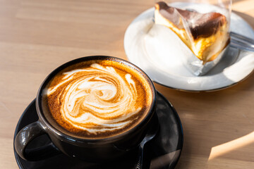 Hot coffee latte with latte art milk foam in cup mug and Homemade chocolate cake wood desk on wood desk on top view. As breakfast In a coffee shop at the cafe,during business work concept