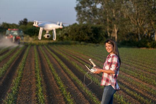 Farmer woman driving drone in field