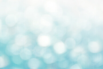 Defocused Bright abstract winter blue background with white shimmering sunspots. Bokeh. Holiday festive concept. Copy space for text. Merry Christmas and Happy New Year