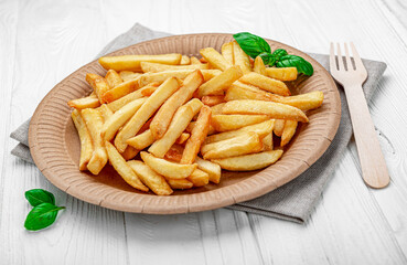 French fries. Fried potatoes on a paper plate.
