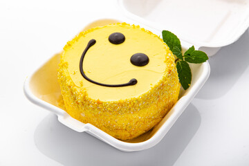 Bento cake with smiley face pattern and hearts in plastic box-packaging.