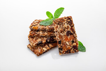 Energy granola bars with different seeds, nuts and dried fruits and berries on a white background