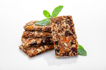 Energy granola bars with different seeds, nuts and dried fruits and berries on a white background