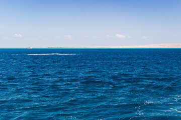 Beautiful seascape near Hurgada, Coast in Egypt Red Sea. Amazing nature background Luxury holiday resort. Boat on the horizon among the blue sea surface