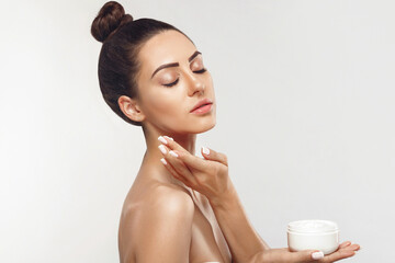 Beauty Woman Concept. Skin care.  Portrait of female model holding and applying cosmetic...