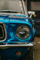Classic Ford Mustang convertible in blue, parked in the city. Ford mustang is one of the most...