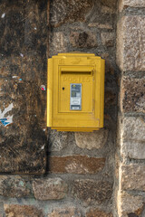 Yellow post box on a road in the French Pyrenees