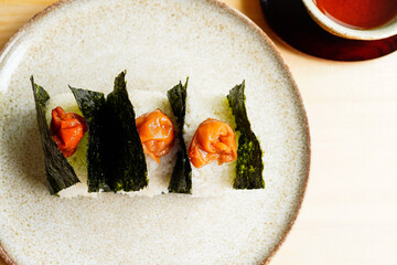 High-angle shot of Onigiri wrapped in nori with umeboshi on top 