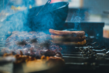 Cooking shish kebab on skewers. Meat, vegetables and bread rolls baked on coals.A male chef roasts juicy beef, chicken, pork.The concept of street food. Grilled meat on the grill.Meat on the barbecue.