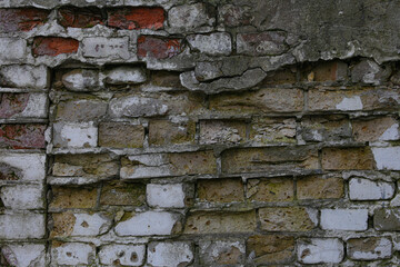 Old Red brick wall with crumbled bricks. The texture of an old dark brown and red brick wall. Stone wall texture. Old brick wall. 