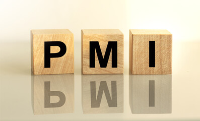 The inscription PMI on wooden cubes isolated on a light background, the concept of business and finance.