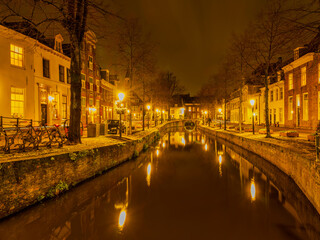 Beautiful dutch street lit up at night on a canal side in Amersfoort, Netherlands