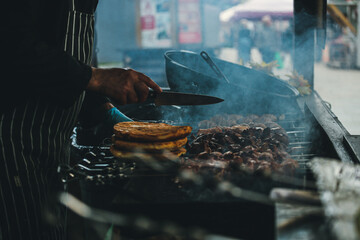 Cooking shish kebab on skewers. Meat, vegetables and bread rolls baked on coals.A male chef roasts...