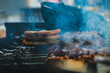 Cooking shish kebab on skewers. Meat, vegetables and bread rolls baked on coals.A male chef roasts juicy beef, chicken, pork.The concept of street food. Grilled meat on the grill.Meat on the barbecue.