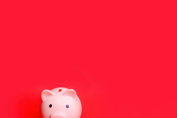 Pink piggy bank isolated against red background Savings and loan crisis Saving money is the key to...