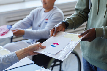 Close up of young African American man receiving voting ballot on election day, copy space