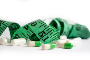 Measuring tape, pills on a light background