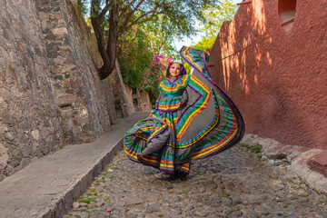 Young Mexican woman in a traditional folklore dress of many colors, traditional dancer.