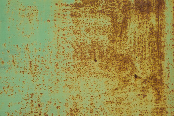 Background is sheet rusty and old metal with peeling green paint.
