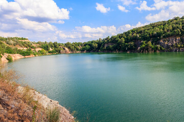 Fototapeta na wymiar View of the lake at abandoned quarry on summer