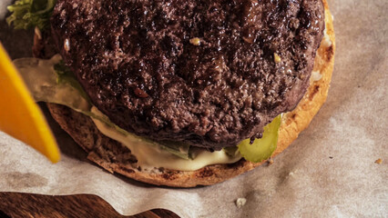 making a burger, puts a slice of cheese on top of a juicy cutlet. Close-up