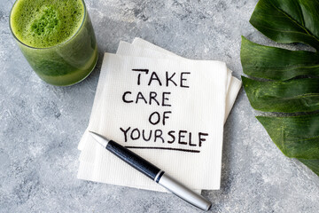 Take care of yourself, inspirational handwriting on a napkin with a glass of green juice. Encouragement.Positive energy Concept.