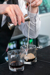 Fototapeta na wymiar Closeup of a bartender's hands pouring cocktail.