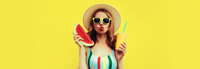 Summer colorful portrait of beautiful young woman blowing her lips with slice of watermelon and cup of juice wearing straw hat on yellow background, blank copy space for advertising text