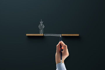 Wooden blocks and a drawn figure with a chasm, the hand draws a bridge, a passage. Concept of help...