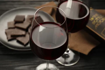 Fotobehang Tasty red wine and chocolate on black wooden table, closeup © New Africa