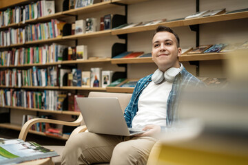 Online lesson male student studying at college uses a laptop, video chat, sits in a lecture hall