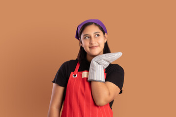 young Mexican brunette woman with kitchen clothes and smiling and happy expression showing