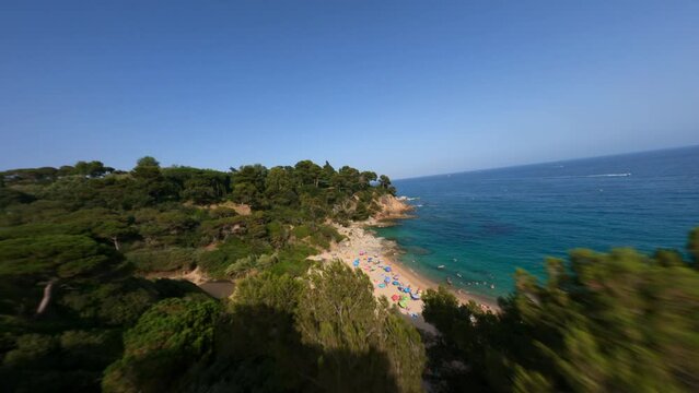 Dynamic fpv shot along the beach full of colourful umbrellas 